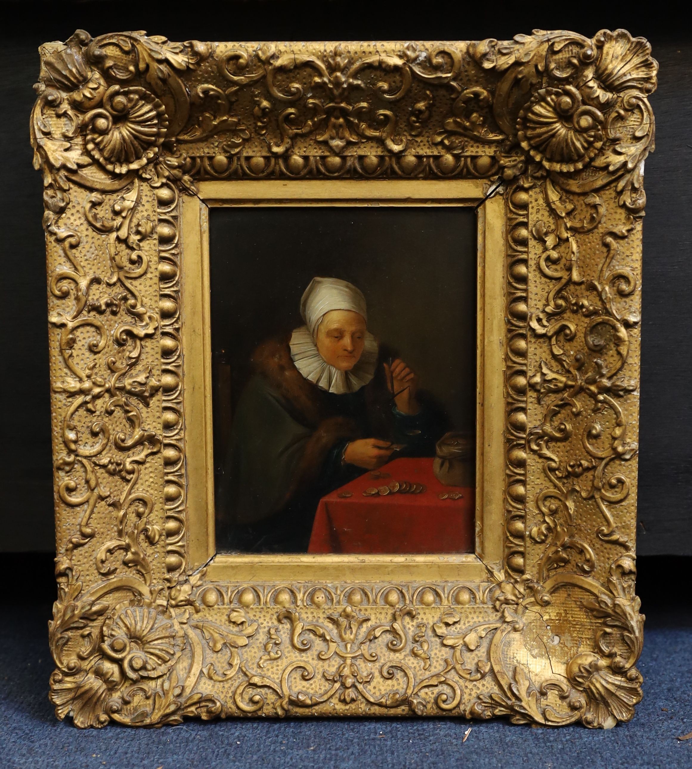 18th century Flemish School, Woman seated at a table counting money, oil on wooden panel, 18.5 x 14cm